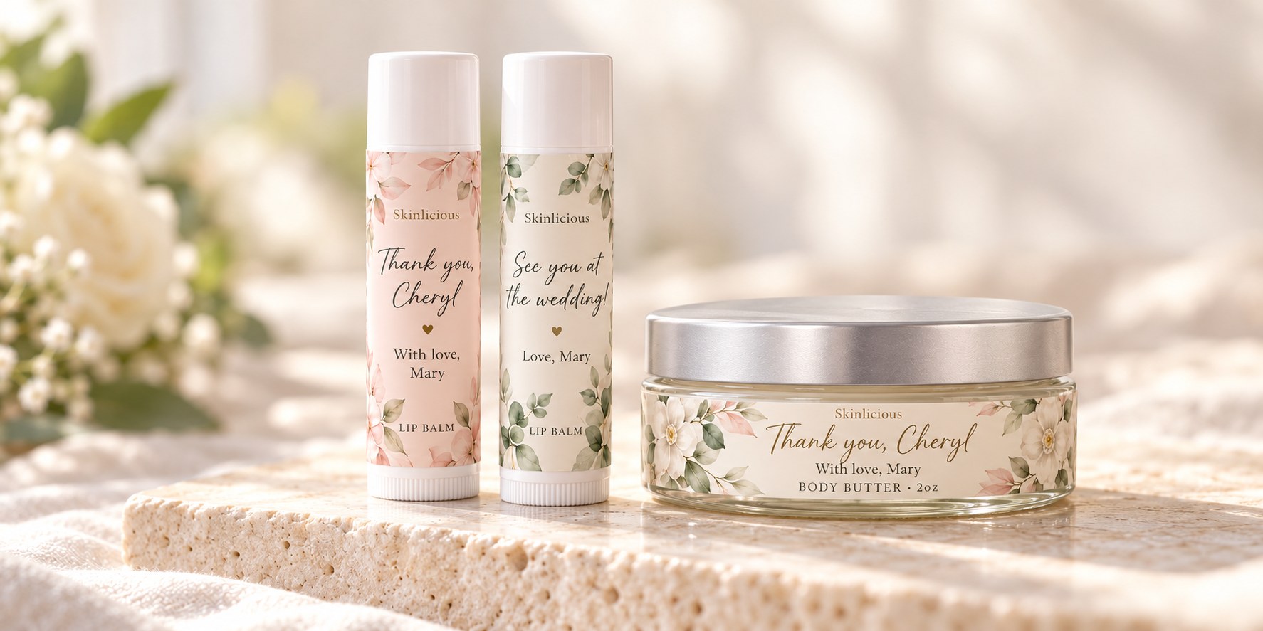 Illustrative personalized blush and sage lip balms beside a silver-lidded 2oz body butter jar